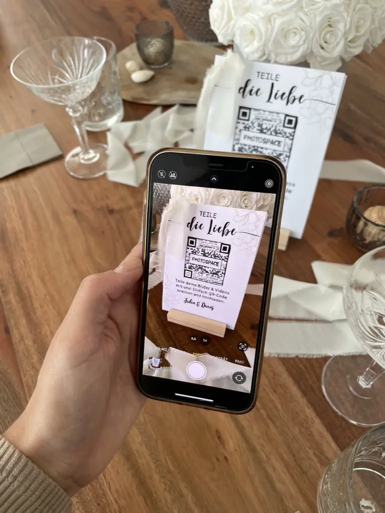 Mann mit Handy scannt QR-Code für Hochzeitsfotos